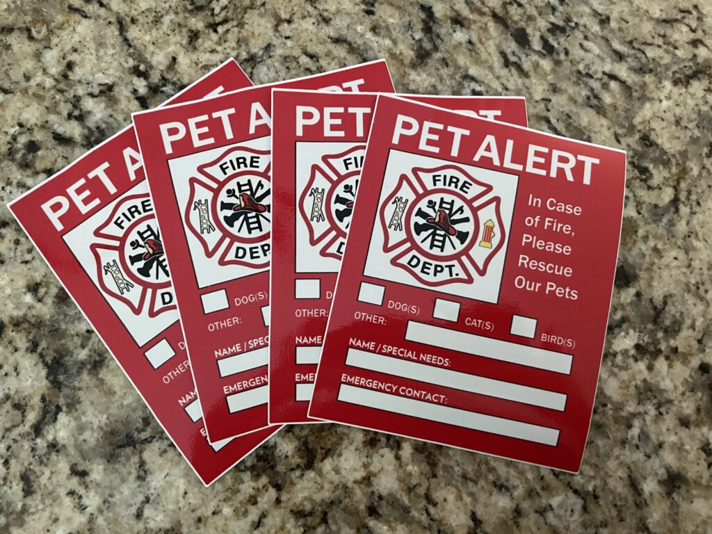 A spread of 4 Pet Alert signs on a counter.