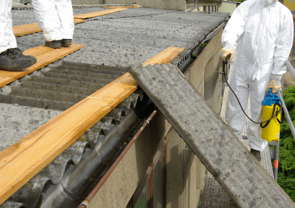 Workers in hazmat suits mitigate asbestos on tiles.